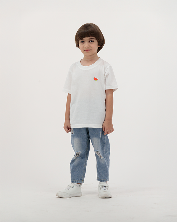 Young boy in Batikh Kids T-Shirt featuring colorful watermelon and fruit print.
