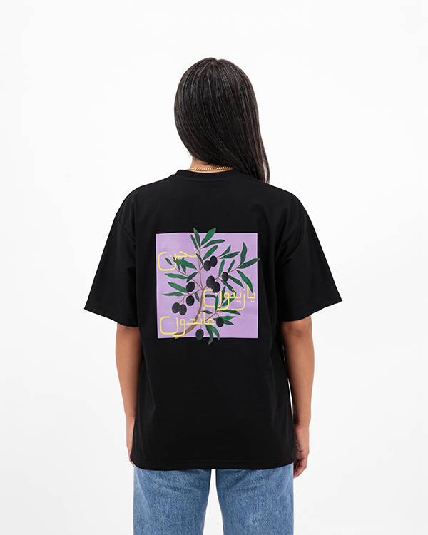 Woman wearing Zeitoon Black Oversized T-Shirt with olive branch print on back.