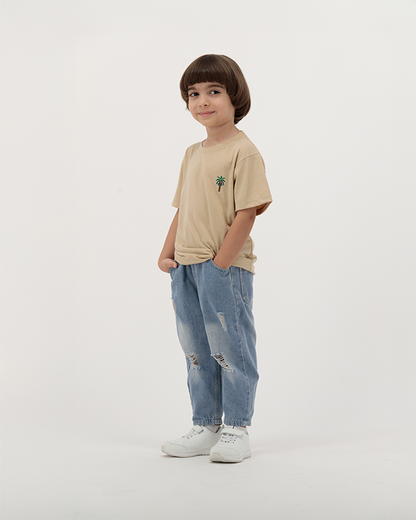 Boy dressed in The Palm Kids Leaf Print Tee with colorful palm artwork on back.