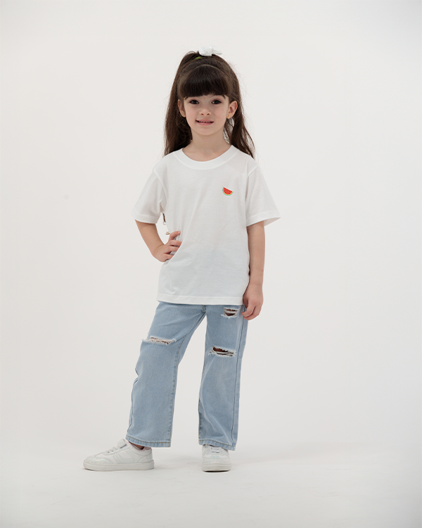 Girl in white Batikh Kids T-Shirt featuring colorful watermelon and fruit print.