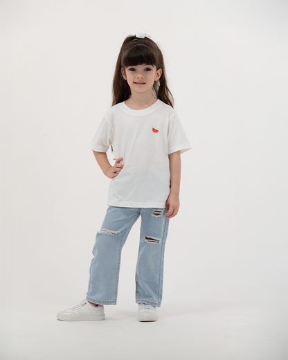 Girl in white Batikh Kids T-Shirt featuring colorful watermelon and fruit print.