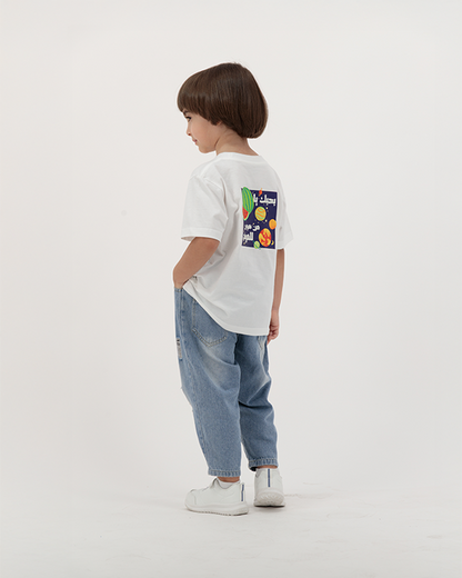 Kid boy wearing Batikh Watermelon Print Tee with colorful fruit artwork.