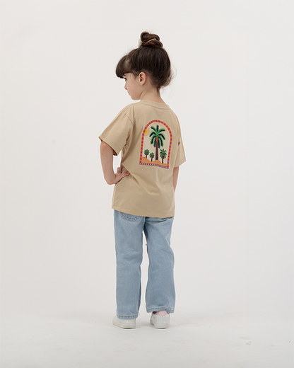 Kid girl wearing The Palm Kids T-Shirt with palm and sun design.