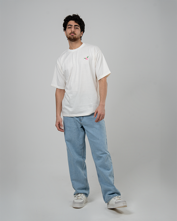 Male model in white Jasmine Oversized T-Shirt featuring jasmine flower design.